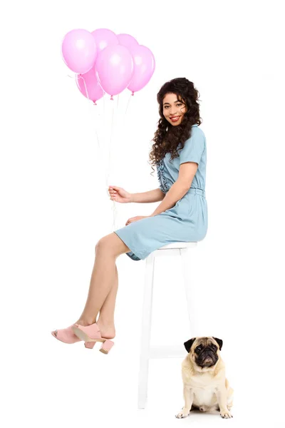 Schöne junge Frau mit rosa Luftballons und Mops Welpen isoliert auf weiß — Stockfoto