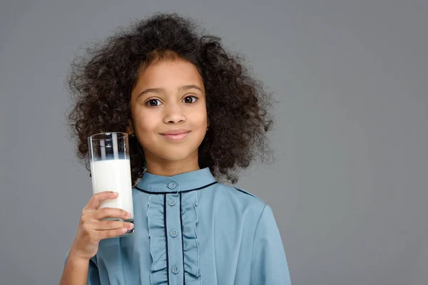 Smiling little child with glass of milk isolated on grey — Stock Photo