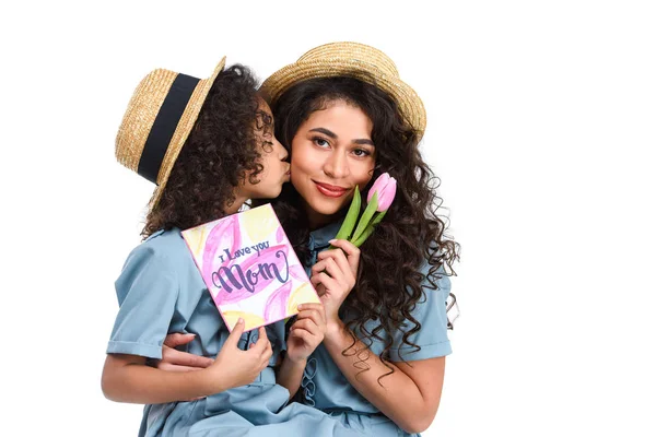 Filha com mães dia cartão de saudação e tulipa beijando sua mãe isolada no branco — Fotografia de Stock