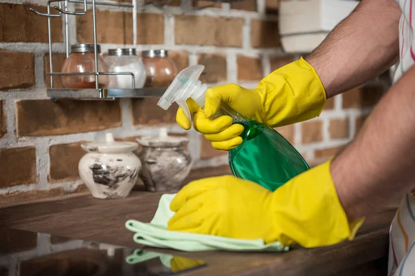 Imagem cortada do homem cozinha de limpeza com frasco de spray e pano — Fotografia de Stock