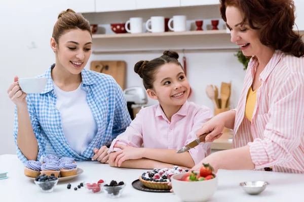 Tre generazioni di donne che trascorrono del tempo insieme in cucina con i dolci in cucina — Foto stock