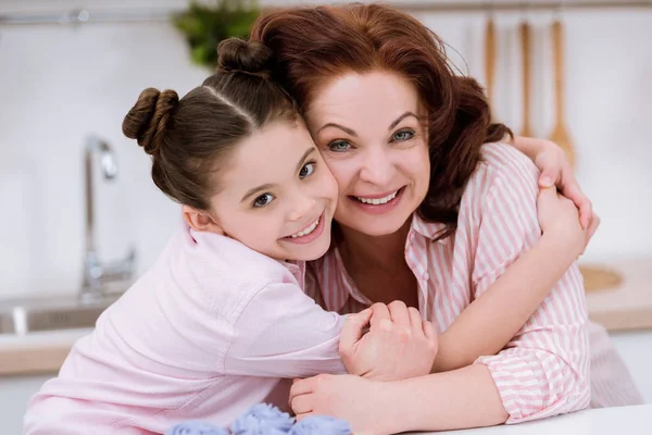 Close-up portrait of embracing grandmother and little granddaughter looking at camera — Stock Photo