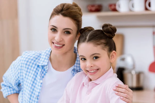 Portrait en gros plan de jeune mère et fille heureuses regardant la caméra — Photo de stock