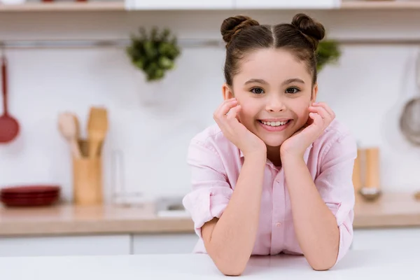 Entzückendes kleines Kind in der Küche blickt in die Kamera — Stockfoto