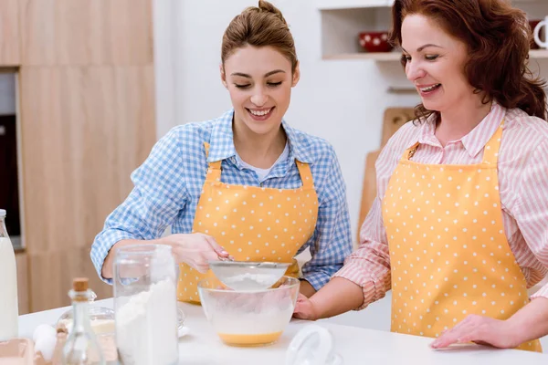 Joven y su madre preparando masa para pastelería juntos - foto de stock