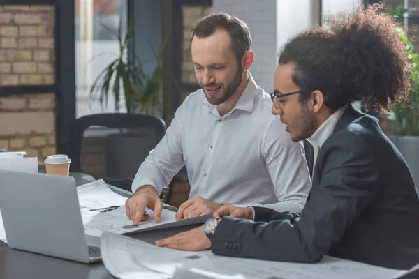 Felice bello architetti discutendo piani di costruzione in ufficio — Foto stock