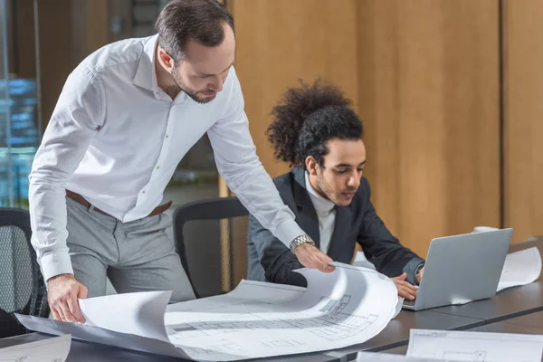 Architects working with building plans together at office — Stock Photo