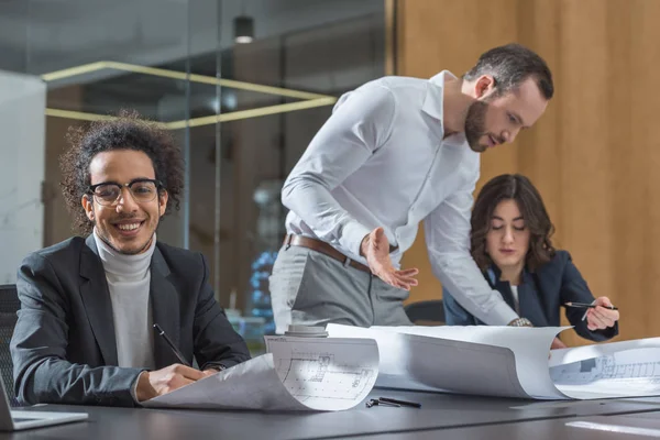 Team junger Architekten diskutiert Baupläne — Stockfoto