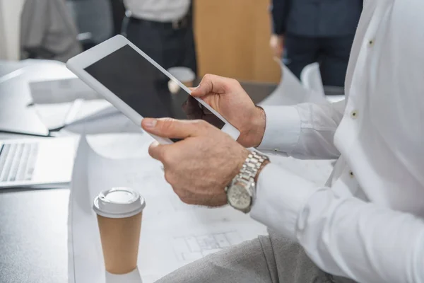 Cropped shot of architect using tablet over building plans — Stock Photo