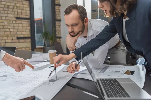 Team di architetti che misurano i piani di costruzione con bussola insieme in ufficio — Foto stock