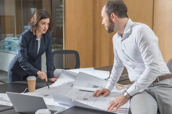 Architekten diskutieren gemeinsam Baupläne in modernem Büro — Stockfoto