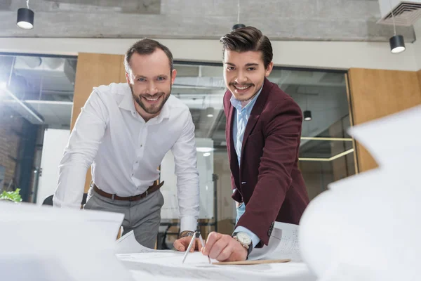 Close-up shot of handsome architects working with building plans at office — Stock Photo
