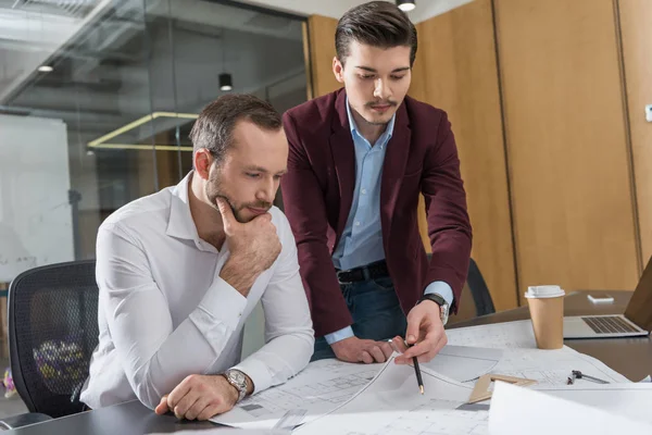 Thoughtful architects brainstorming over building plans at office — Stock Photo