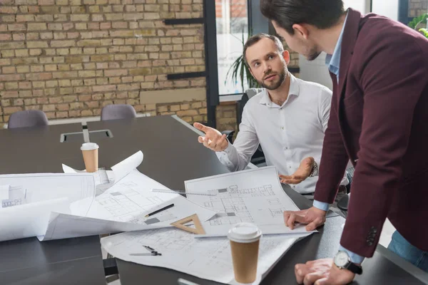 Erfolgreiches Architekten-Brainstorming über Baupläne im Büro — Stockfoto