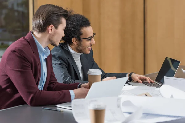 Happy young architects working with laptop together at office — Stock Photo