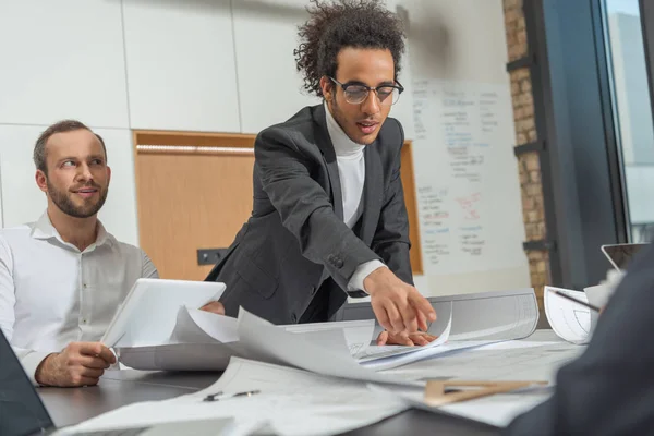 Architectes avec des plans de construction travaillant ensemble au bureau moderne — Photo de stock