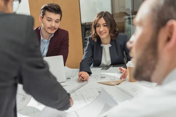 Gruppo di giovani architetti che lavorano insieme sui piani di costruzione in ufficio — Foto stock