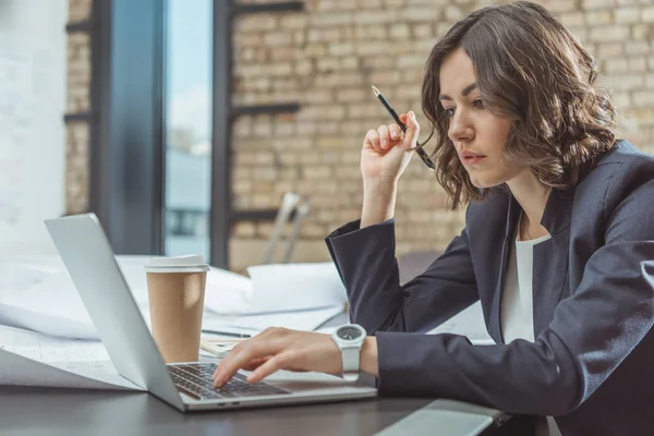 Konzentrierte junge Architektin arbeitet mit Laptop — Stockfoto