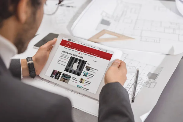 Plan recadré de jeune architecte utilisant une tablette sur le lieu de travail avec le site Web de la bbc à l'écran — Photo de stock