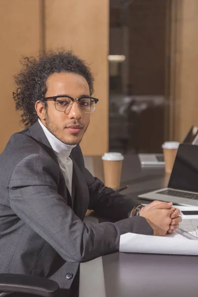 Schöner junger Architekt im Anzug sitzt am Arbeitsplatz im Büro — Stockfoto