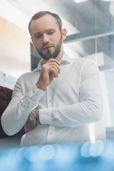 Bottom view of thoughtful architect in white shirt at office — Stock Photo
