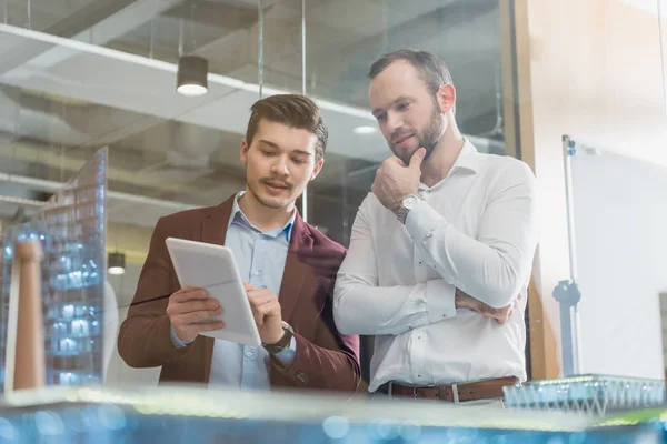 Architekten mit Tablet vor Baumodellen — Stockfoto