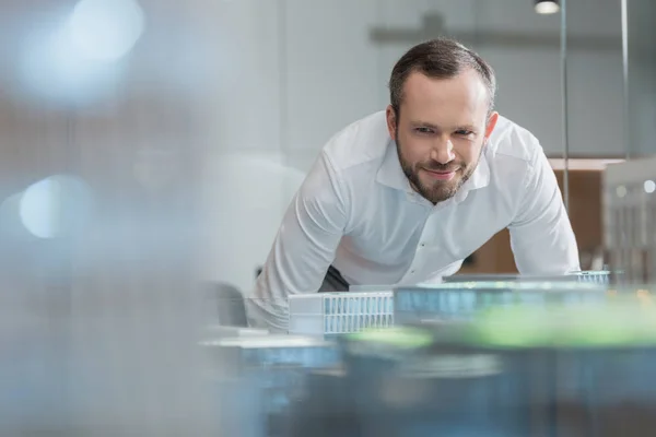 Schöner erfolgreicher Architekt schaut sich Baupläne im Büro an — Stockfoto