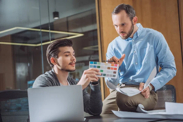 Diseñadores creativos recogiendo color de la paleta juntos en la oficina - foto de stock