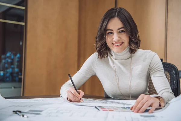 Smiling young designer choosing color from palette — Stock Photo