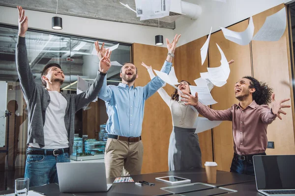 Grupo de empresarios exitosos vomitando documentos en la oficina - foto de stock