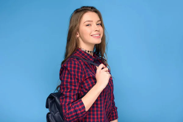 Hermosa joven sonriente chica con mochila, aislado en azul - foto de stock
