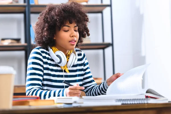African american student with headphones studying alone — Stock Photo