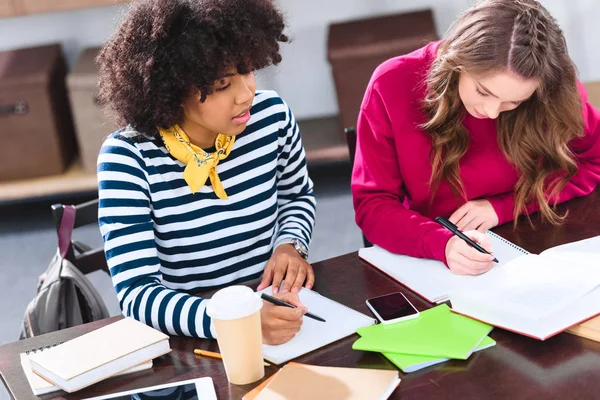 Portrait de jeunes étudiants multiculturels faisant leurs devoirs ensemble — Photo de stock