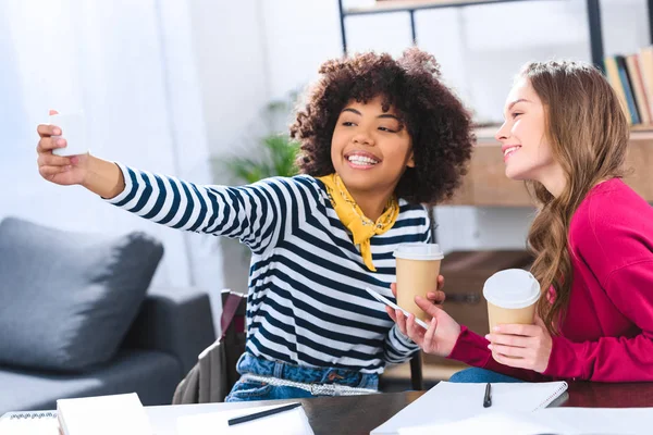 Multicultural students with coffee to go taking selfie together — Stock Photo