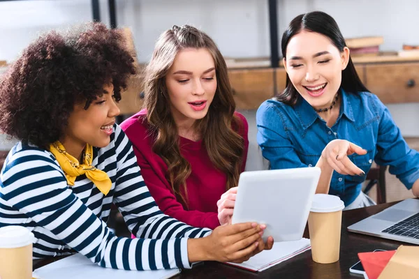 Retrato de jóvenes estudiantes multiétnicos usando tableta juntos - foto de stock