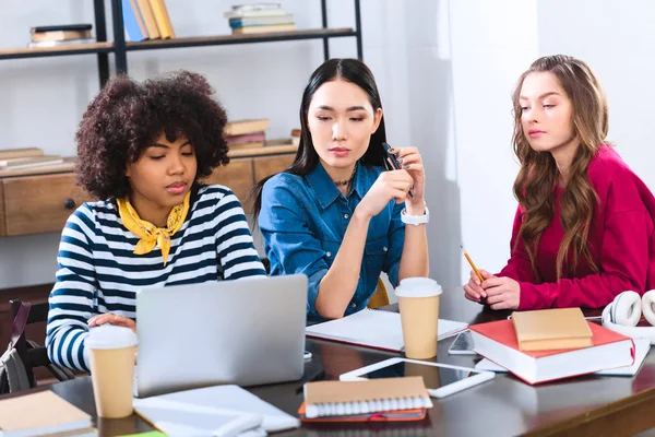 Ritratto di giovani studenti multietnici che usano il computer portatile mentre studiano insieme — Foto stock