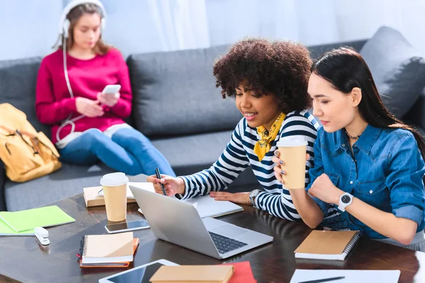 Messa a fuoco selettiva di studenti multirazziali utilizzando computer portatile insieme — Foto stock