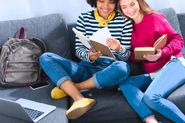 Happy multicultural students studying together on sofa — Stock Photo