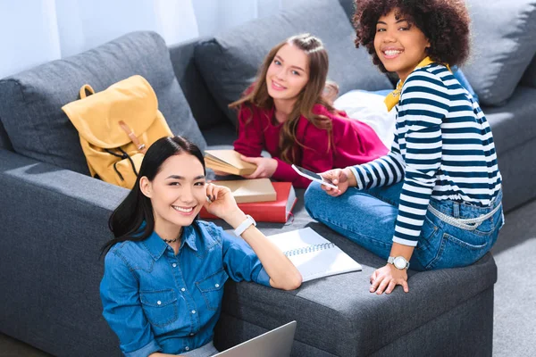 Group of smiling multiethnic students doing homework together — Stock Photo