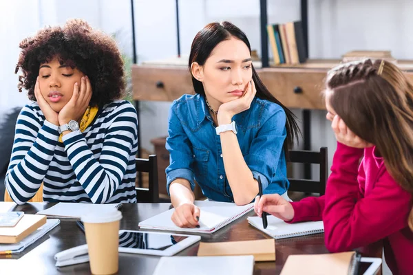 Müde multiethnische Schüler, die gemeinsam Hausaufgaben machen — Stockfoto