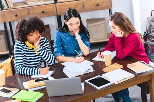 Étudiants multiraciaux ciblés faisant leurs devoirs ensemble — Photo de stock