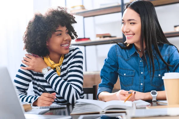 Portrait of cheerful multiracial students doing homework together — Stock Photo