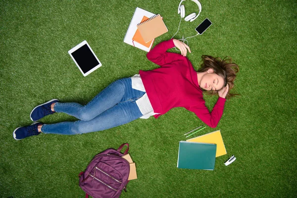 Overhead view of young student sleeping on green lawn — Stock Photo