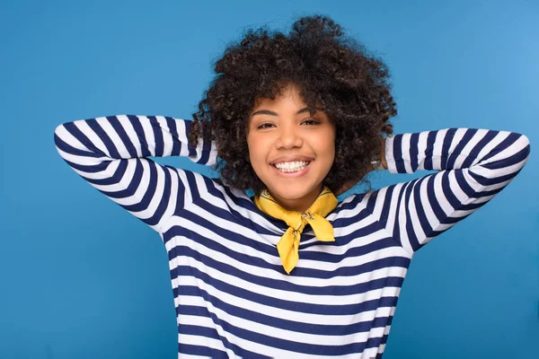 Ritratto di sorridente ragazza afro-americana che guarda la macchina fotografica isolata sul blu — Foto stock