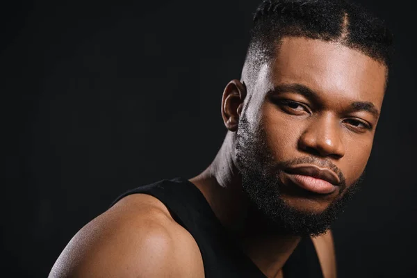 Close-up portrait of handsome young athletic african american man looking at camera isolated on black — Stock Photo