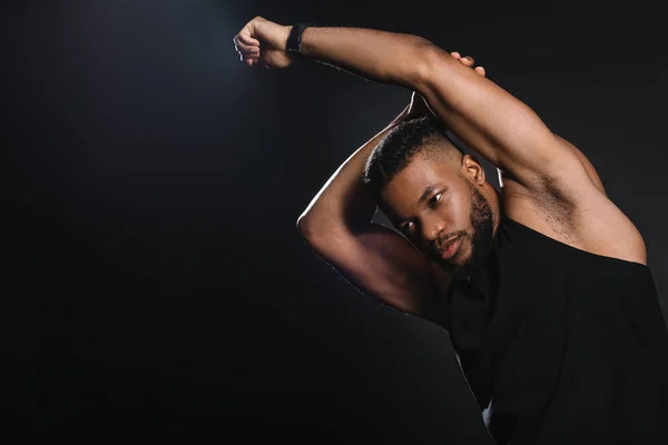 Beau sportif afro-américain musclé étirant les mains isolé sur noir — Photo de stock