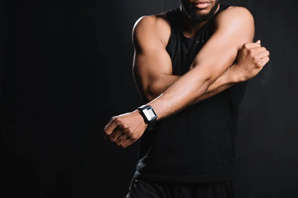 Cropped shot of muscular african american man stretching hands isolated on black — Stock Photo