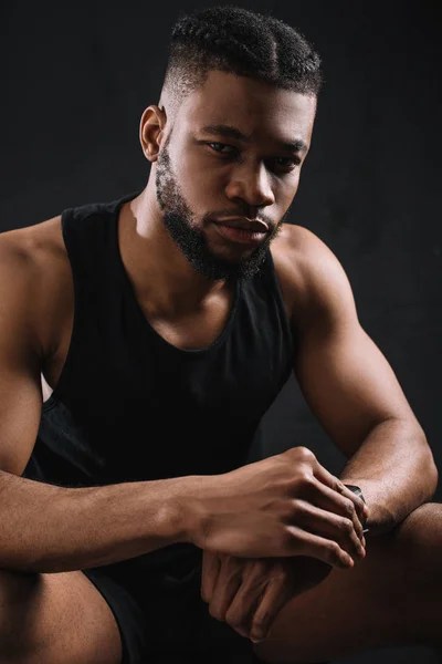 Handsome young african american sportsman looking at camera on black — Stock Photo