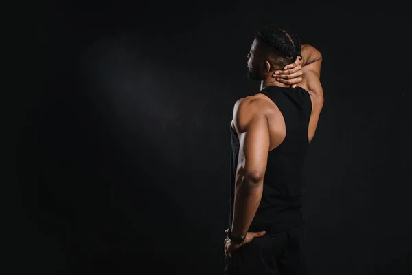 Vue arrière de jeune sportif afro-américain regardant loin isolé sur noir — Photo de stock