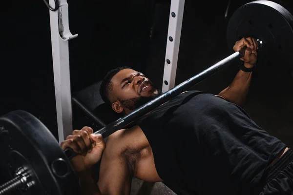 Hochwinkelaufnahme des muskulösen jungen afrikanisch-amerikanischen Sportlers beim Hantelheben — Stockfoto